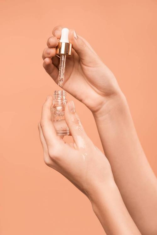 person holding serum bottle